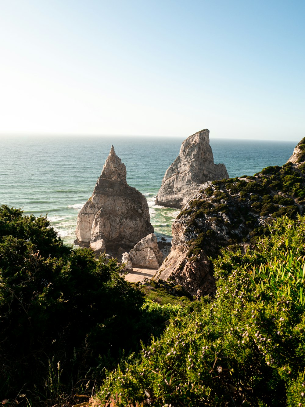 a couple of rocks sitting on top of a lush green hillside