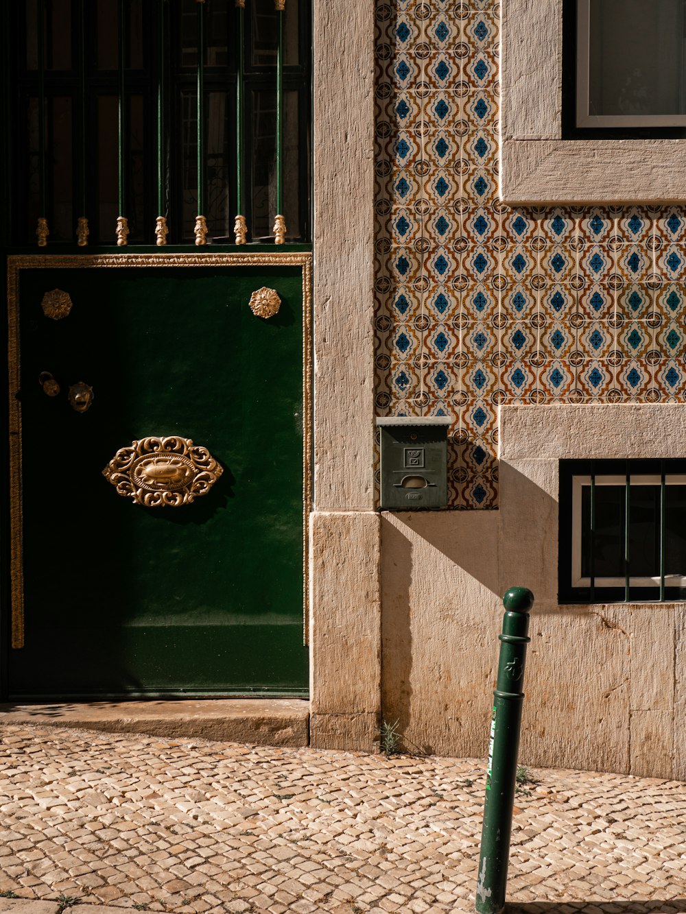 a green door and a green pole in front of a building