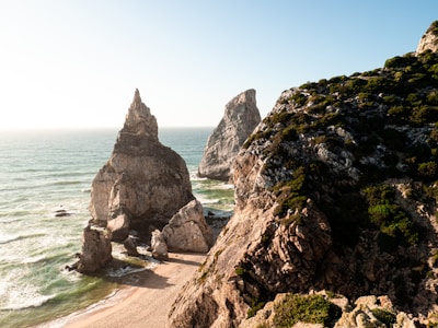 a couple of large rocks sitting on top of a beach