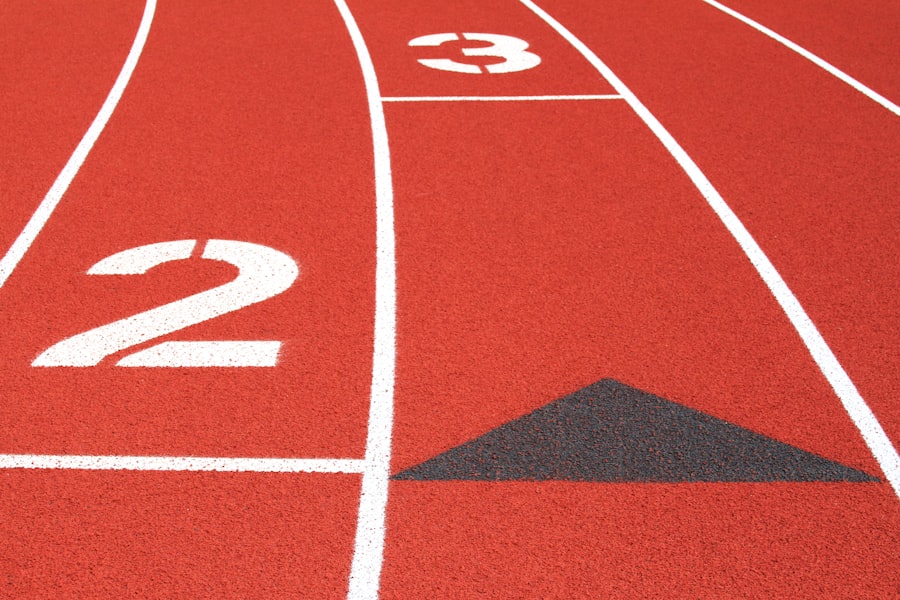 Close-up of numbered lanes on a red athletics track, no athletes in frame