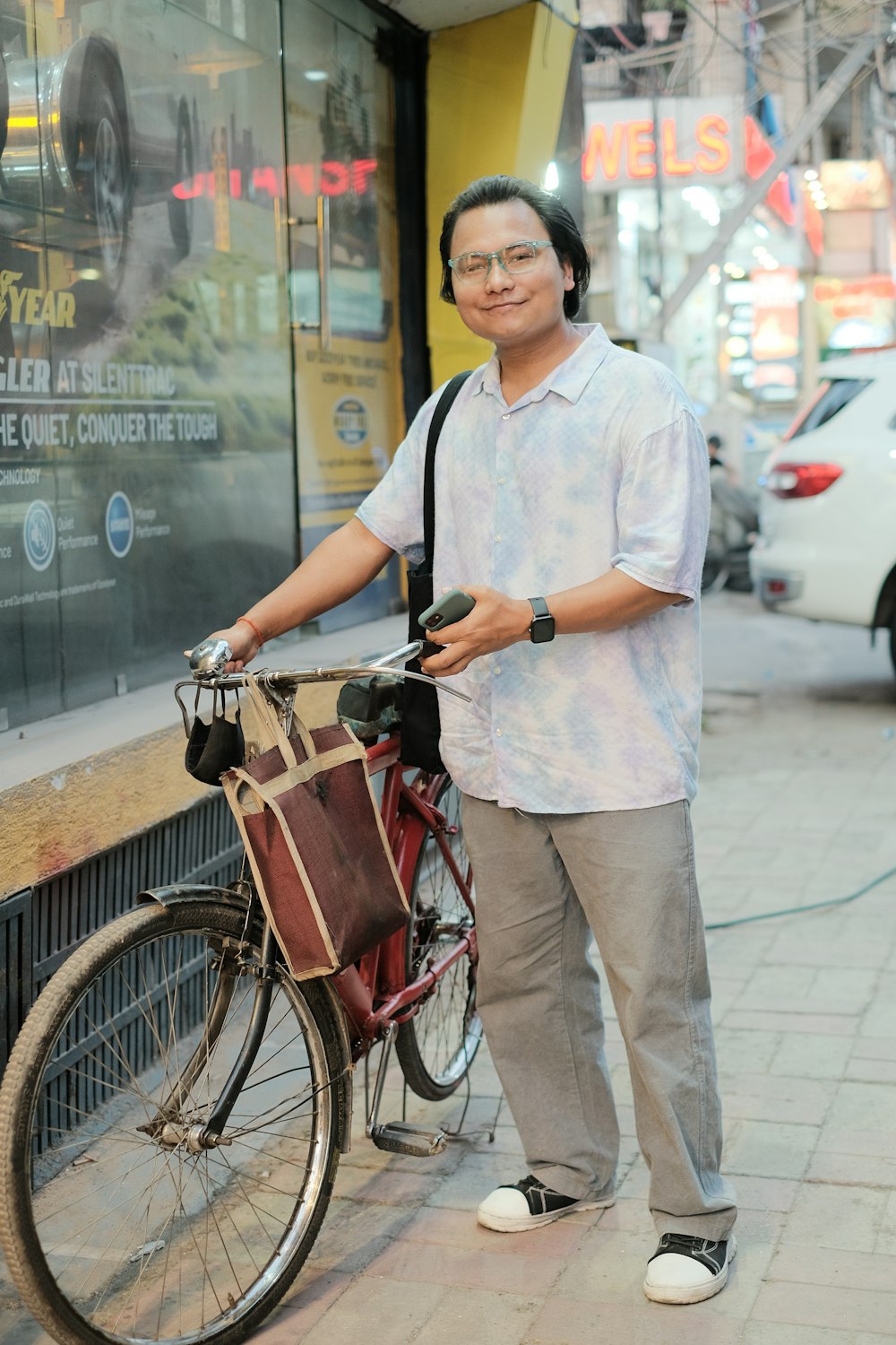 a man standing next to a bike on a sidewalk