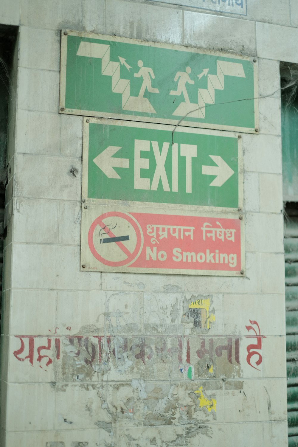 a green exit sign next to a no smoking sign