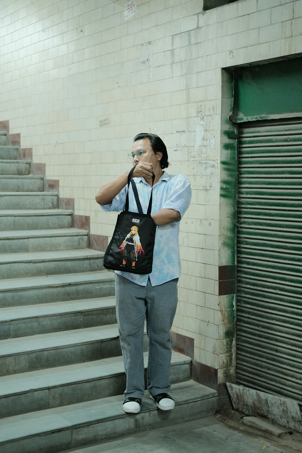 a man standing on a set of stairs holding a bag