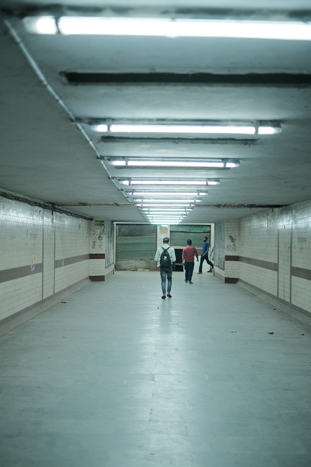 a group of people walking down a long hallway