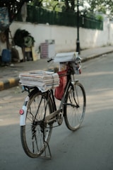 a bicycle with a bunch of papers on the back of it