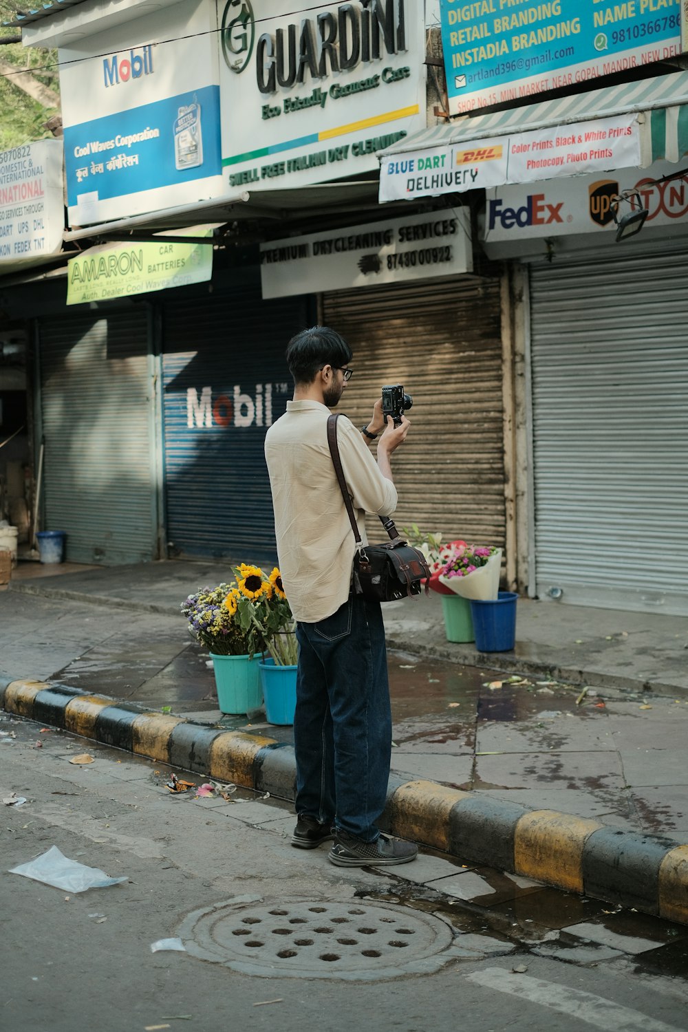 a man standing on a street corner taking a picture