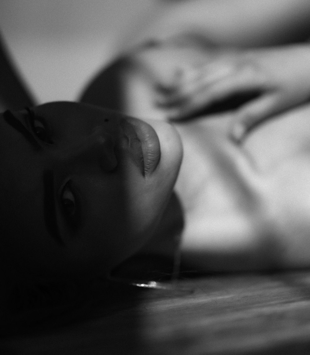 a black and white photo of a woman laying on the floor