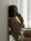 A confident woman posing elegantly in soft, intimate lighting, showcasing boudoir photography style.