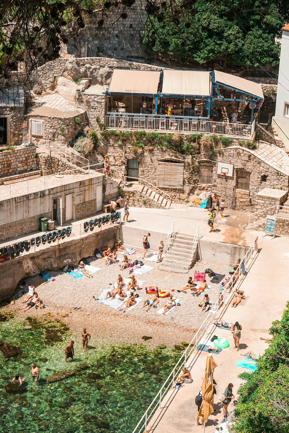 a group of people sitting on top of a sandy beach