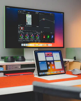 A sleek, minimalist workspace with screens showing film editing and brand designs.