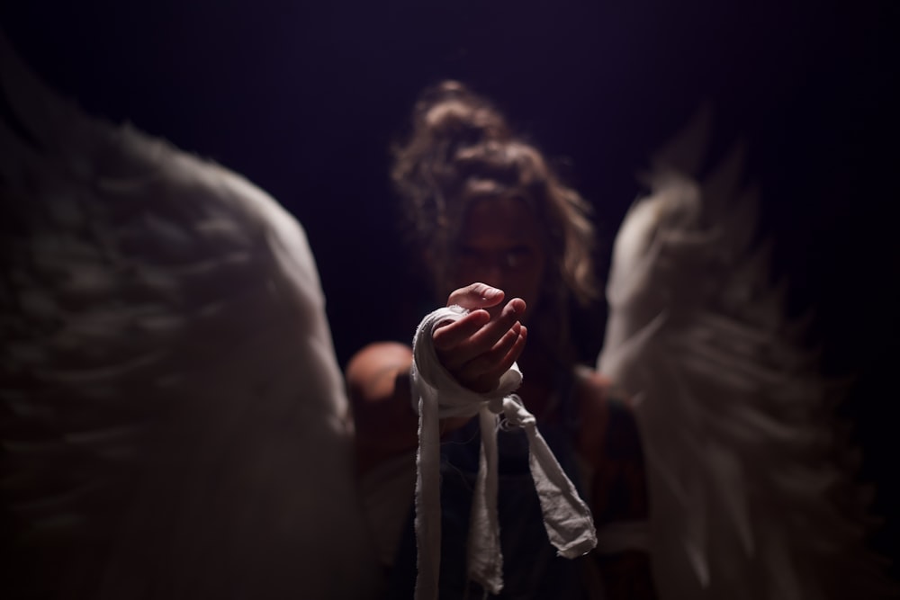 a woman holding a rope with angel wings on it
