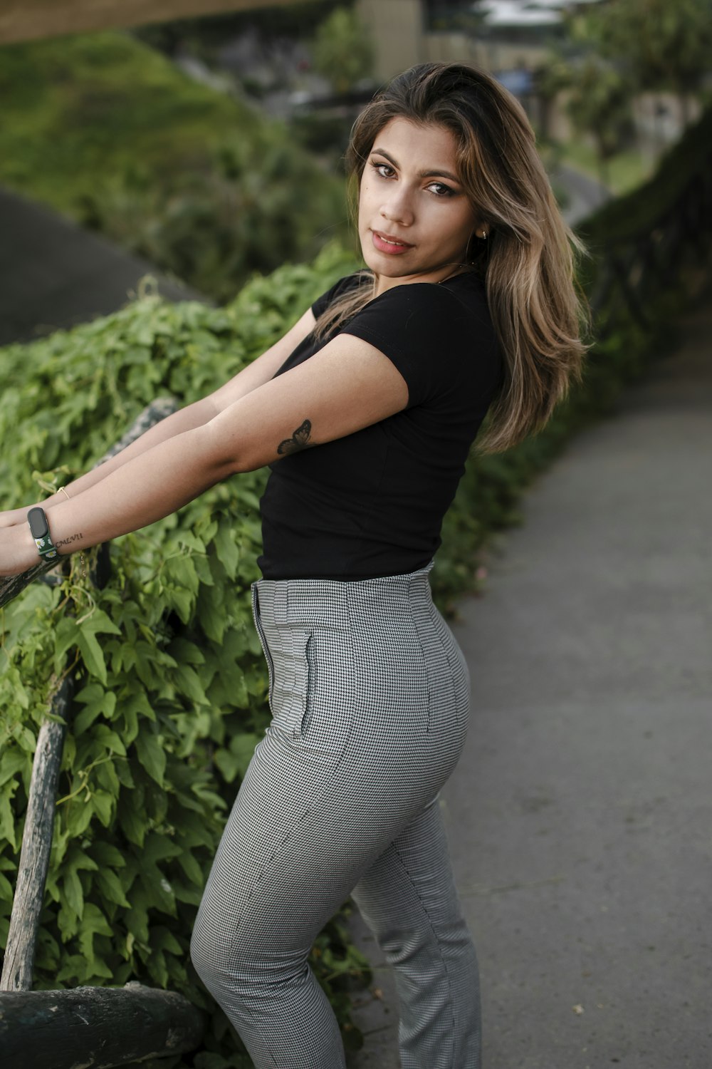 a woman leaning on a fence with her arm extended