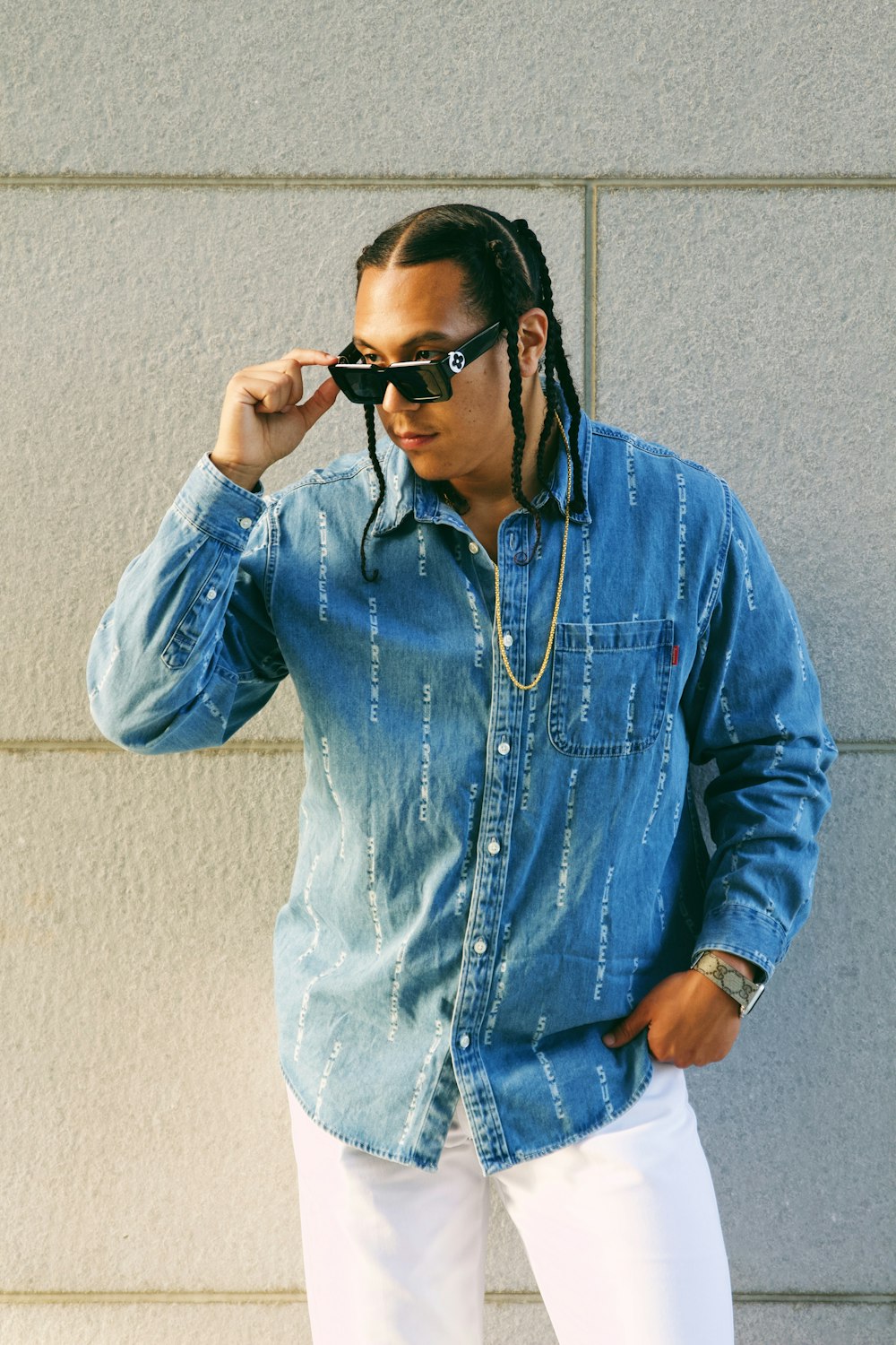 a man with dreadlocks wearing a denim shirt