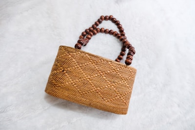 a wooden beaded purse sitting on top of a white surface