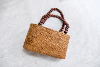 a wooden beaded purse sitting on top of a white surface