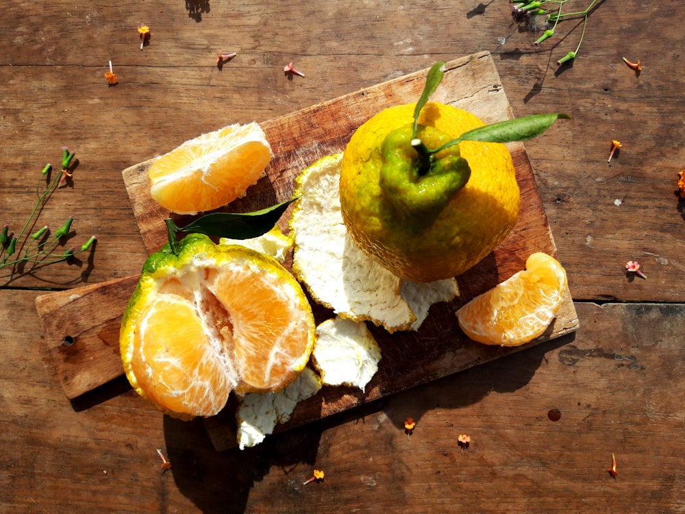 a wooden cutting board topped with sliced oranges