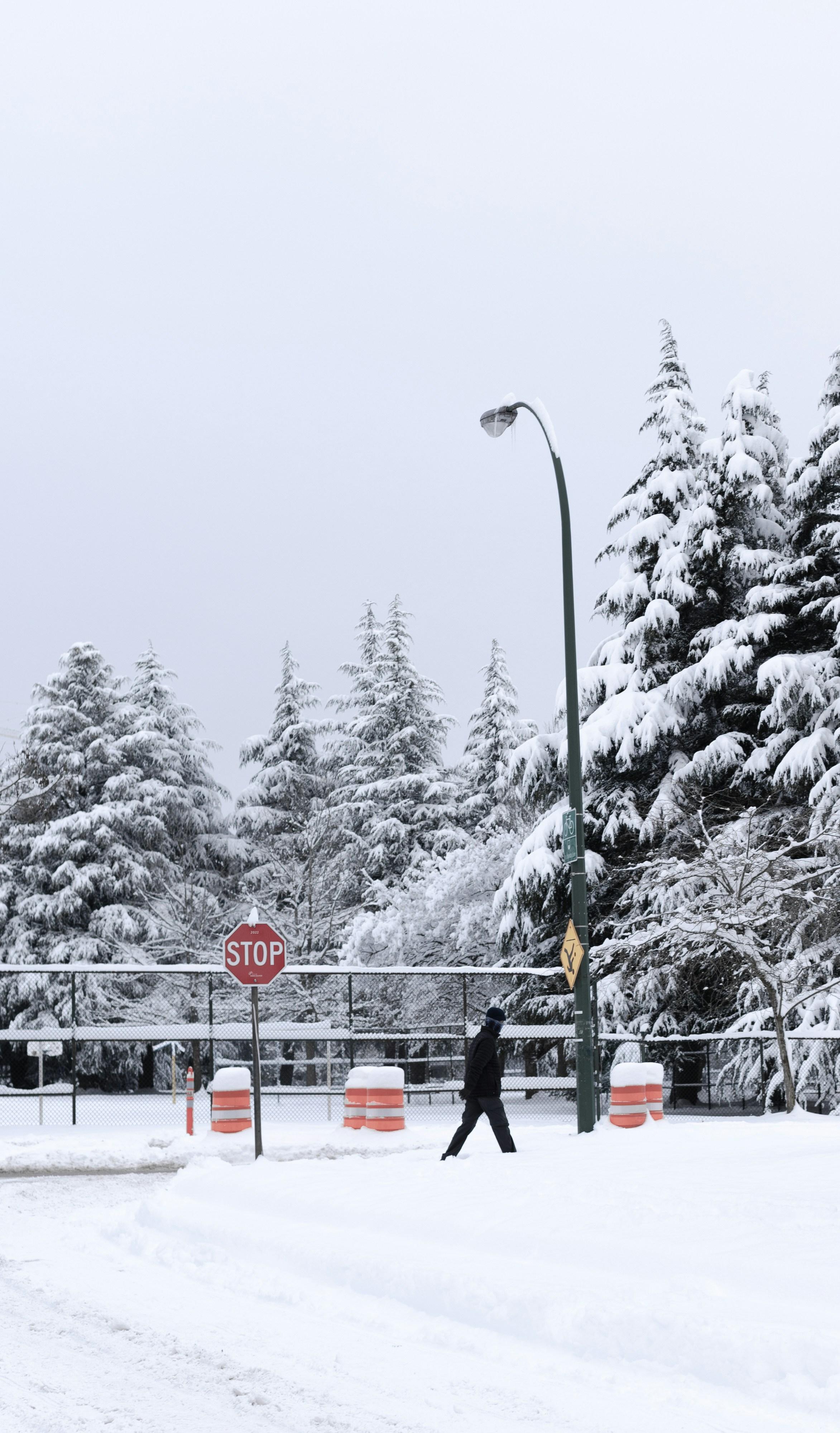 a person walking across a snow covered street