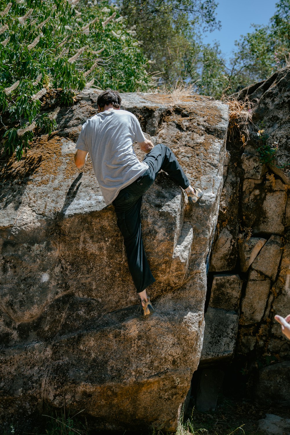 a man is climbing up a large rock