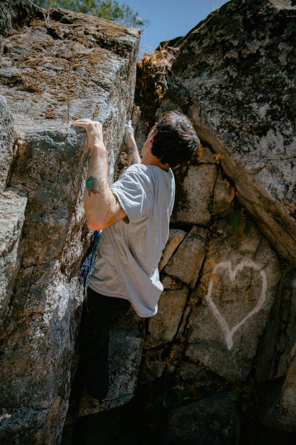 a man climbing up the side of a large rock