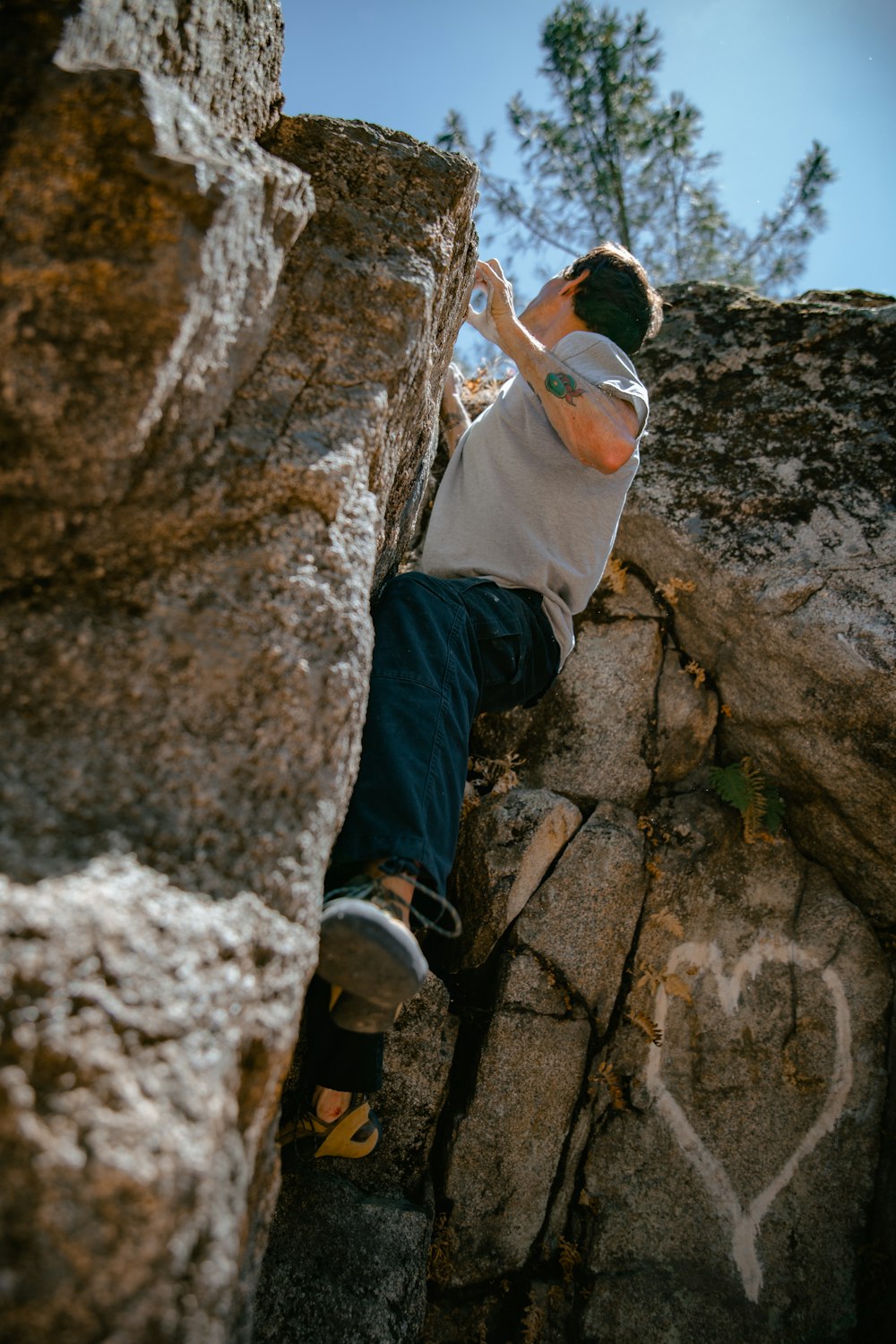 a man climbing up the side of a large rock