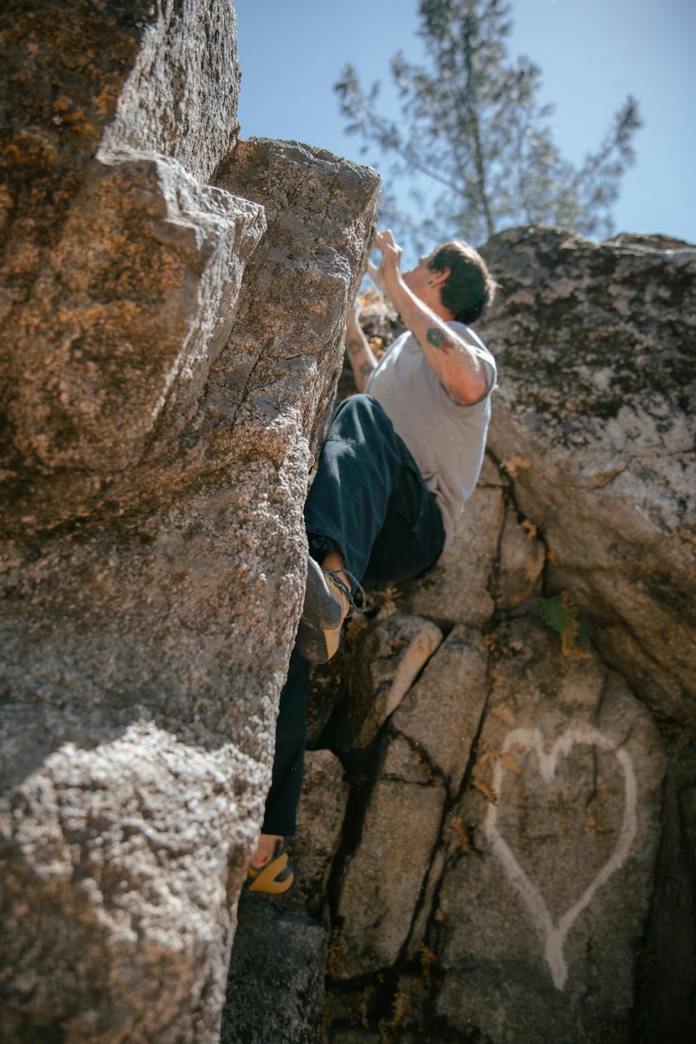 a man climbing up the side of a large rock