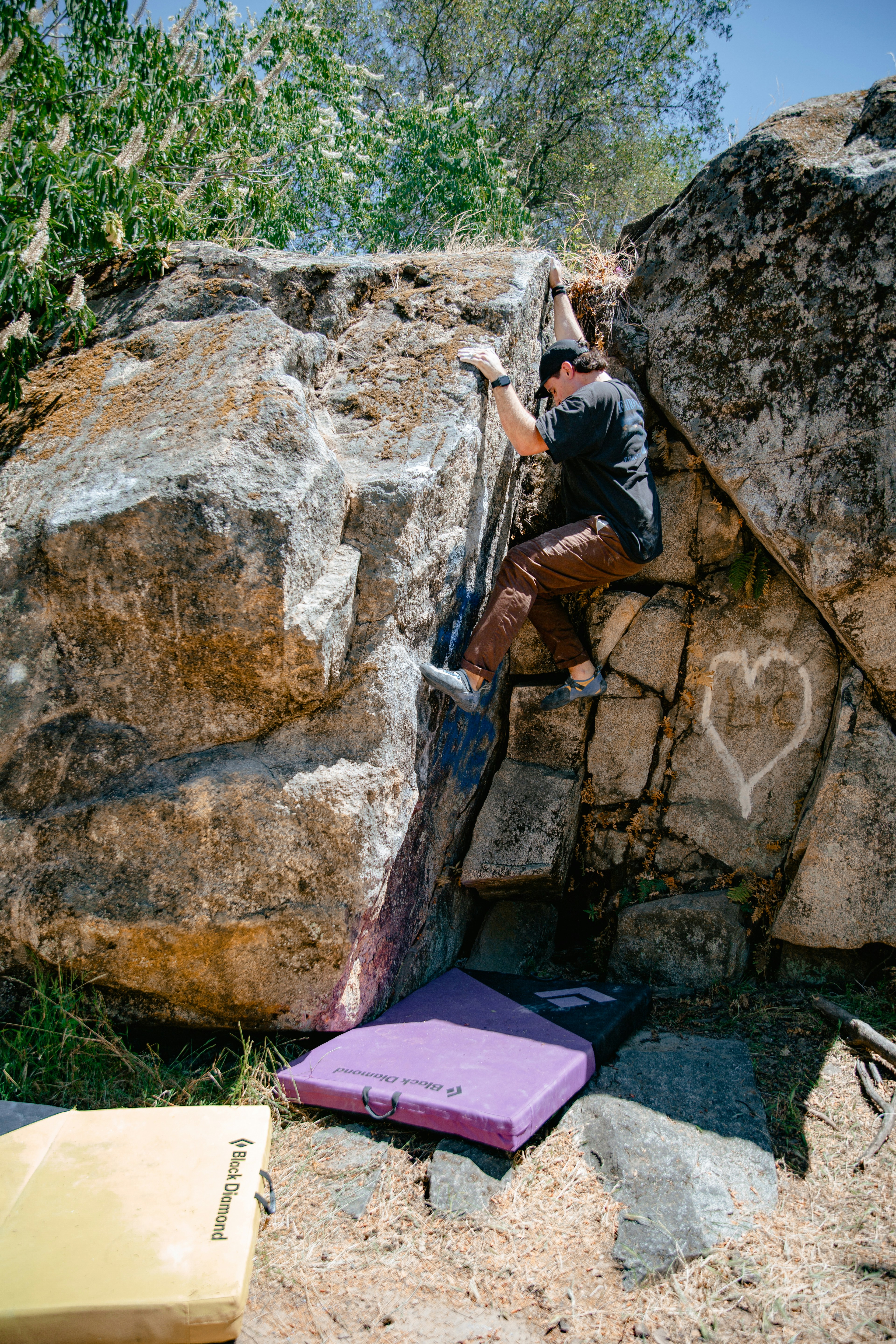 a man climbing up the side of a large rock