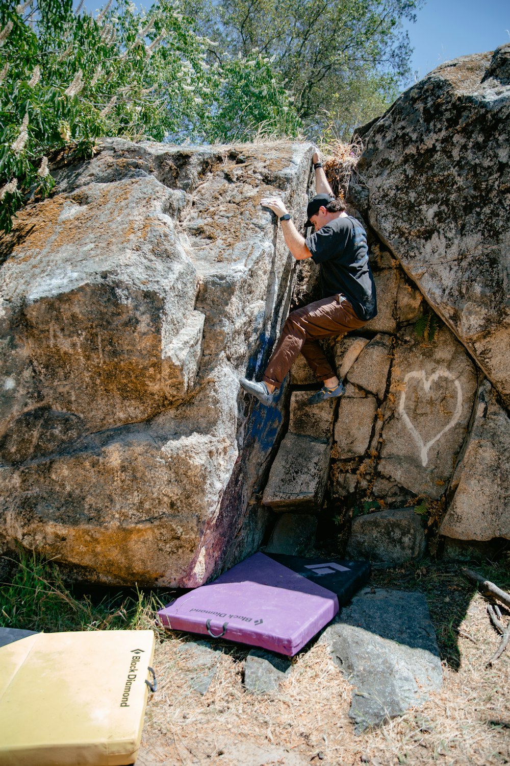 a man climbing up the side of a large rock