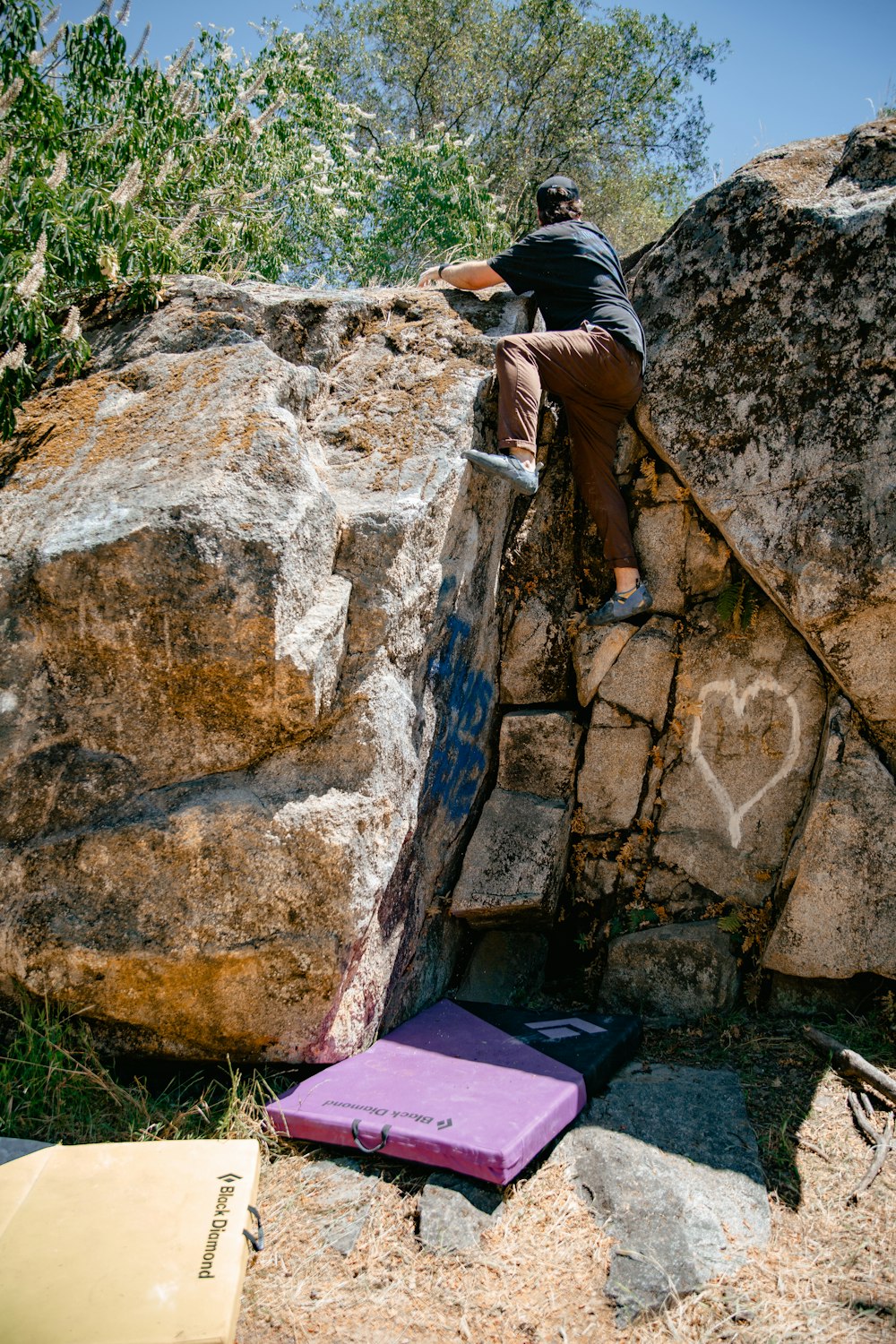 a man climbing up the side of a large rock