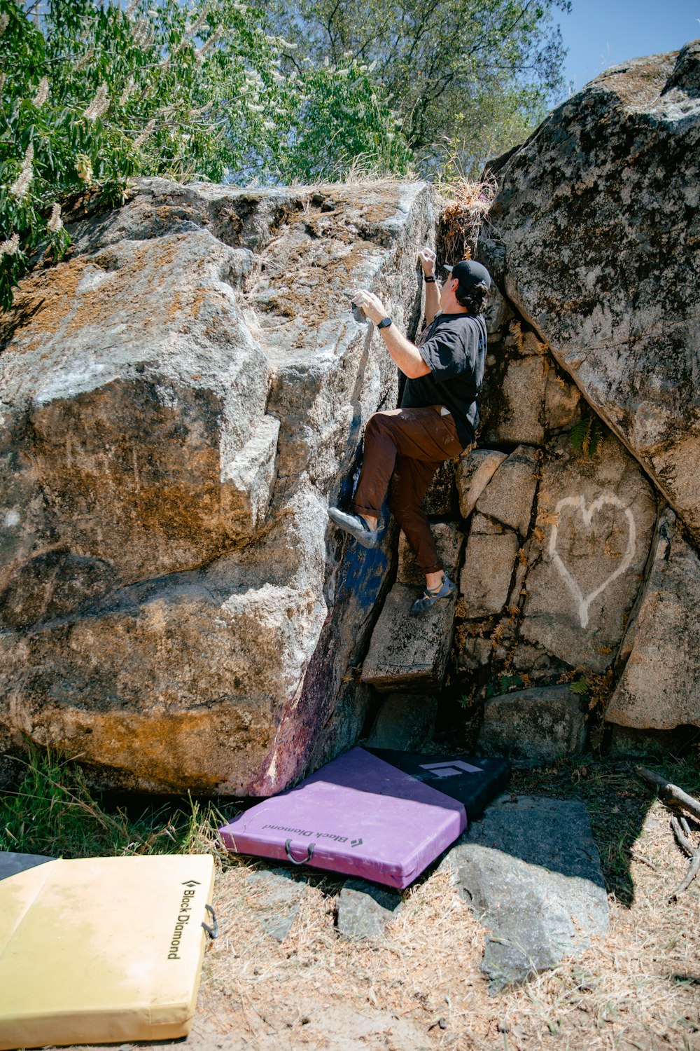 a man climbing up the side of a large rock