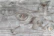A textured wooden surface with visible grain patterns and knot holes. The wood shows natural variations and weathering, giving it a rustic and aged appearance.