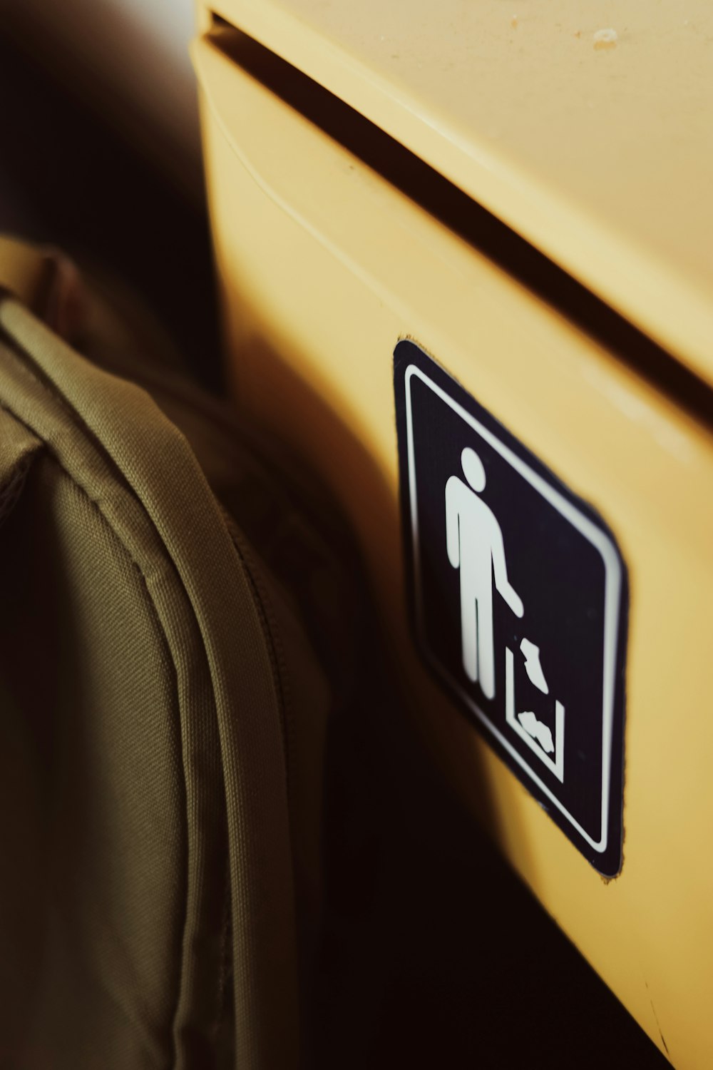 a yellow suitcase with a black and white sign on it