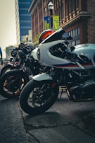 A group of motorcycles lined up in front of a vibrant city mural.