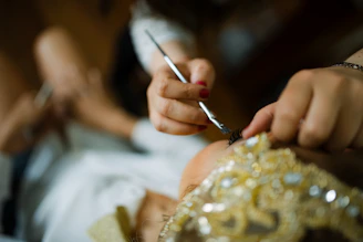 Close-up of a makeup artist applying delicate eye makeup on a bride.