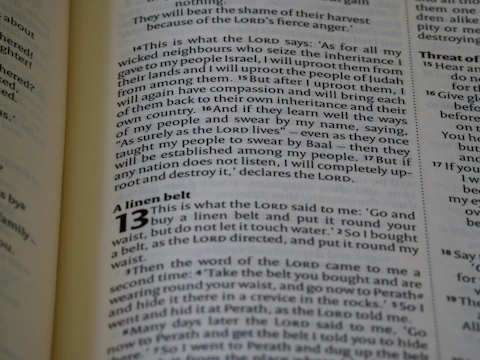 The image captures a page from an open book, likely a Bible, featuring prominently highlighted text in bold and large font, indicating chapter 13, titled 'A linen belt'. The surrounding text includes paragraphs of scripture in smaller font with several verses.