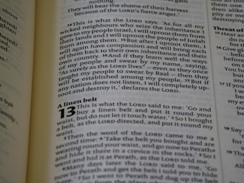 The image captures a page from an open book, likely a Bible, featuring prominently highlighted text in bold and large font, indicating chapter 13, titled 'A linen belt'. The surrounding text includes paragraphs of scripture in smaller font with several verses.