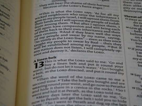 The image captures a page from an open book, likely a Bible, featuring prominently highlighted text in bold and large font, indicating chapter 13, titled 'A linen belt'. The surrounding text includes paragraphs of scripture in smaller font with several verses.