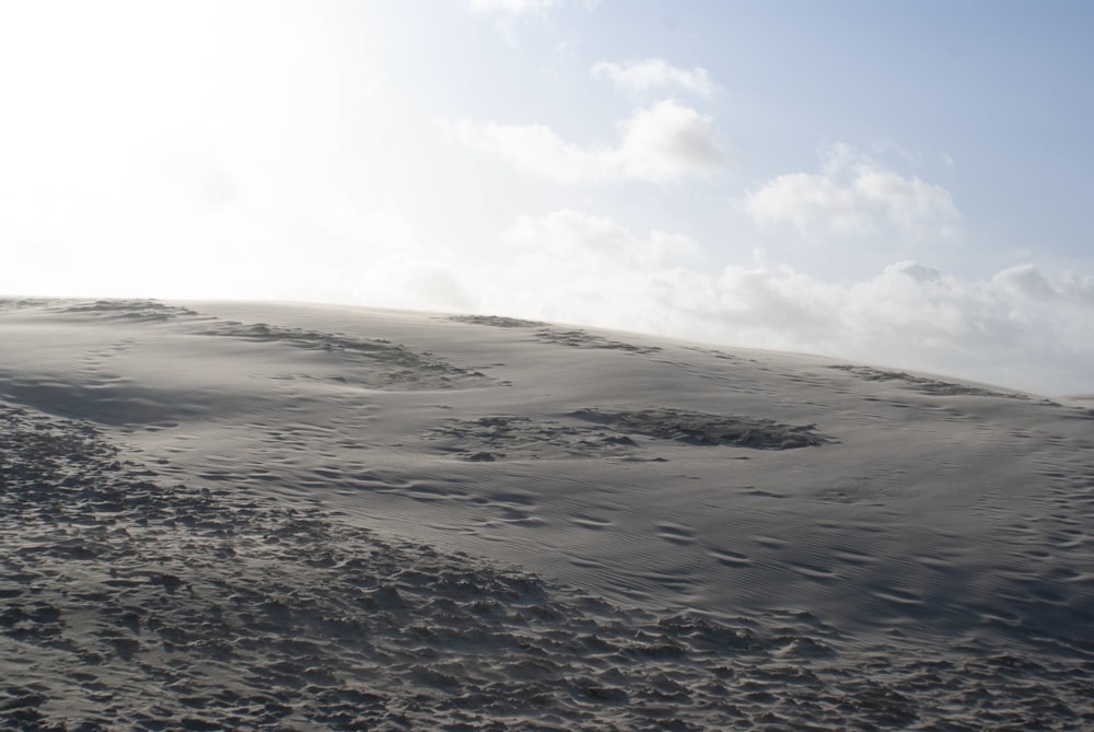 a hill covered in sand under a blue sky