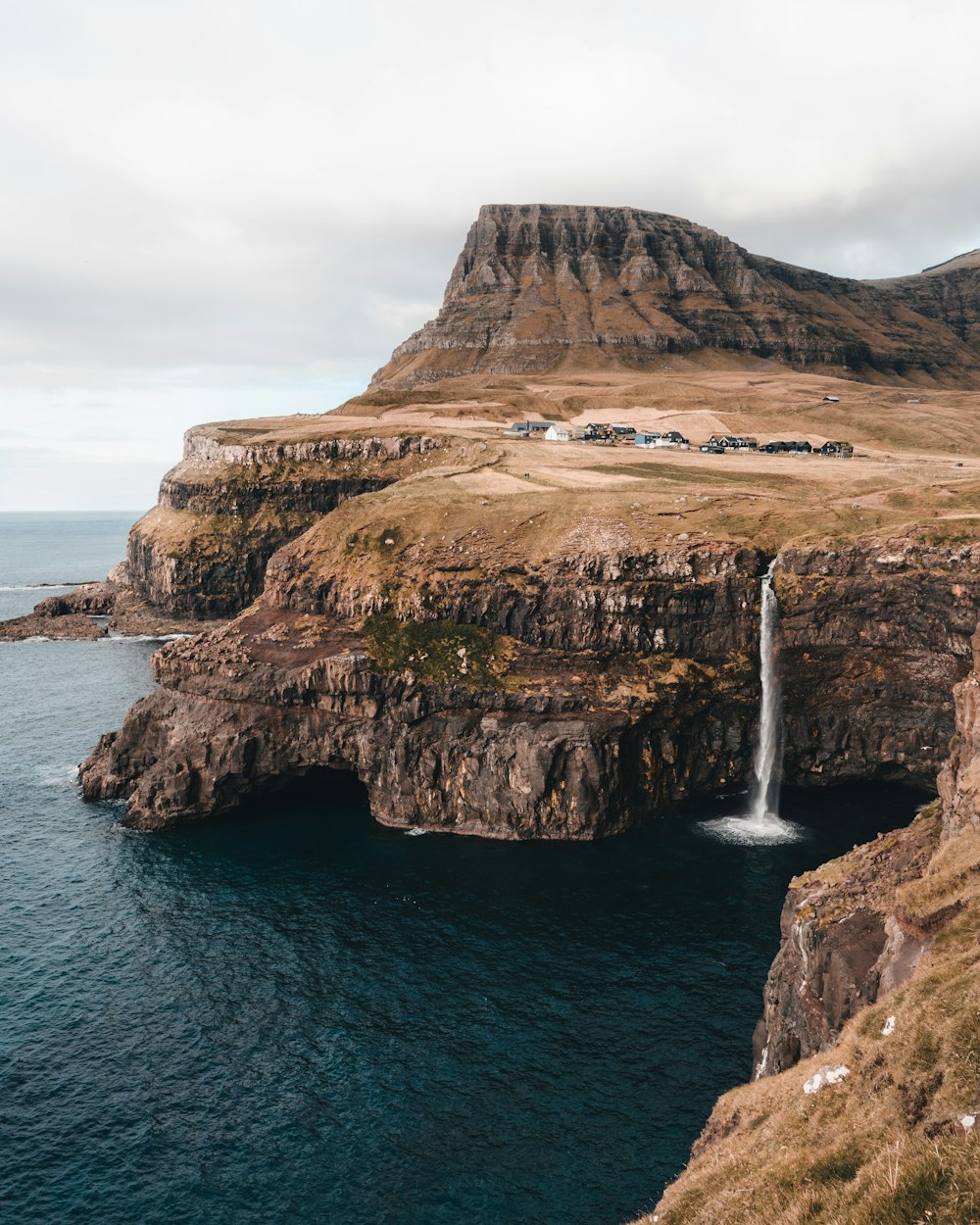 a small waterfall in the middle of a large body of water