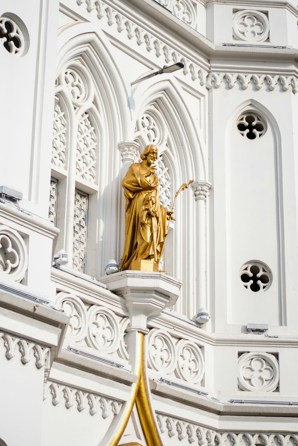 a golden statue on top of a white building