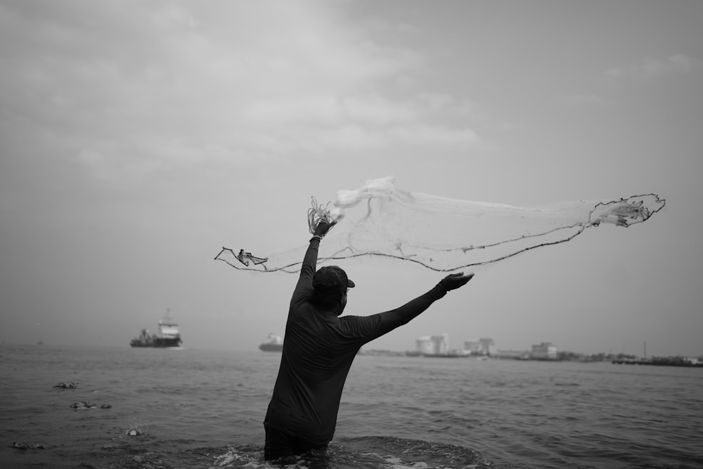 a man standing in the water holding a net over his head