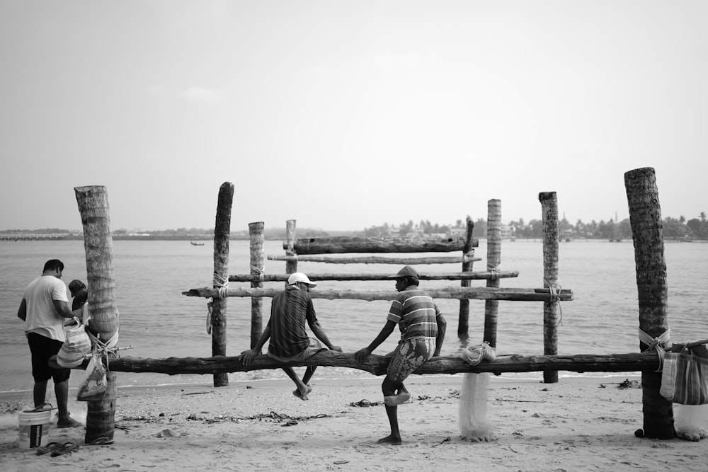 a group of people sitting on top of a wooden bench