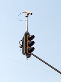 A close-up of a license plate reader camera mounted on a city streetlight.