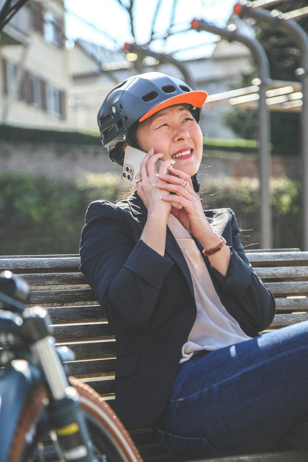 a woman wearing a helmet sitting on a bench