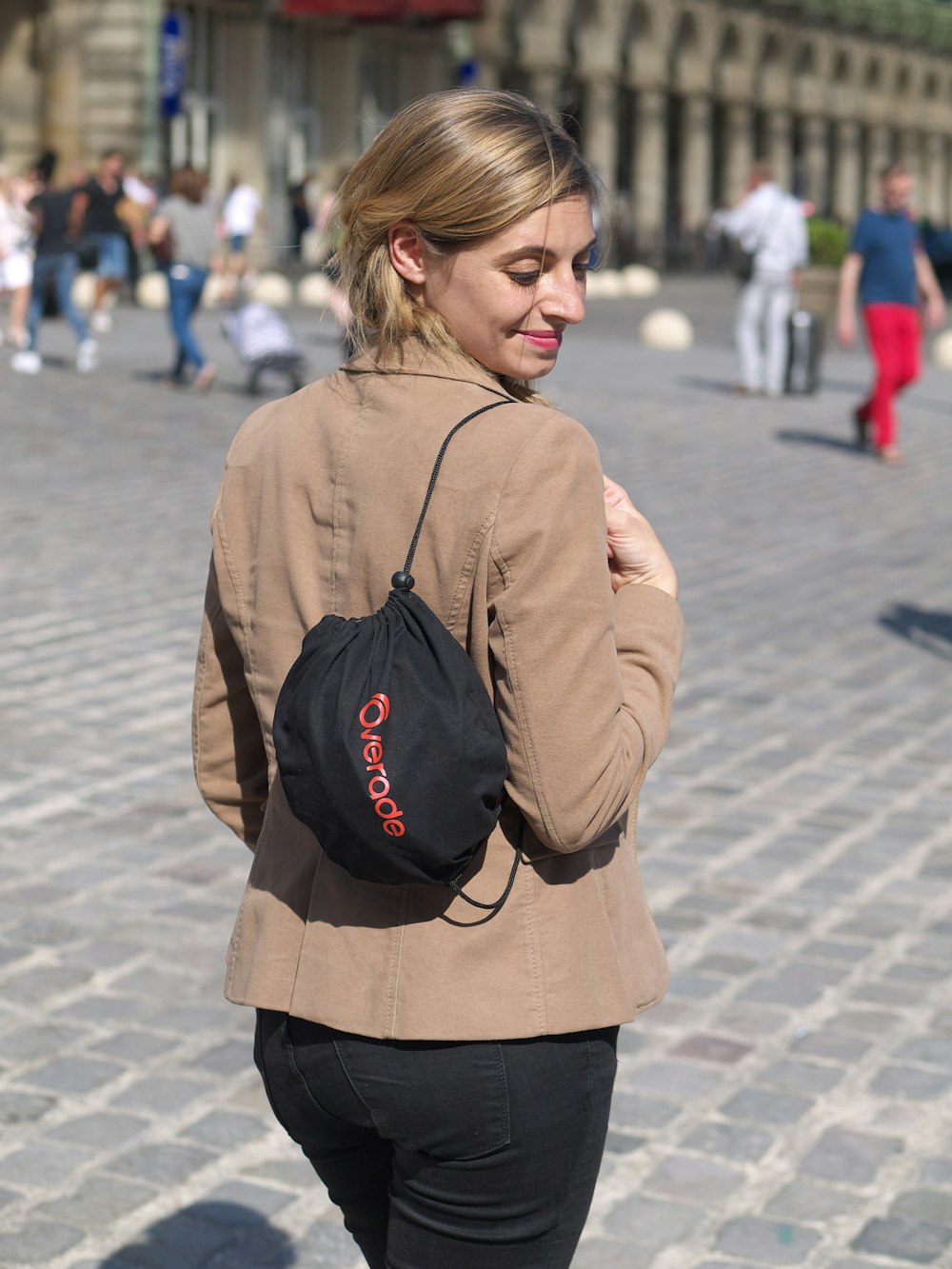 a woman walking down a street with a backpack on her back