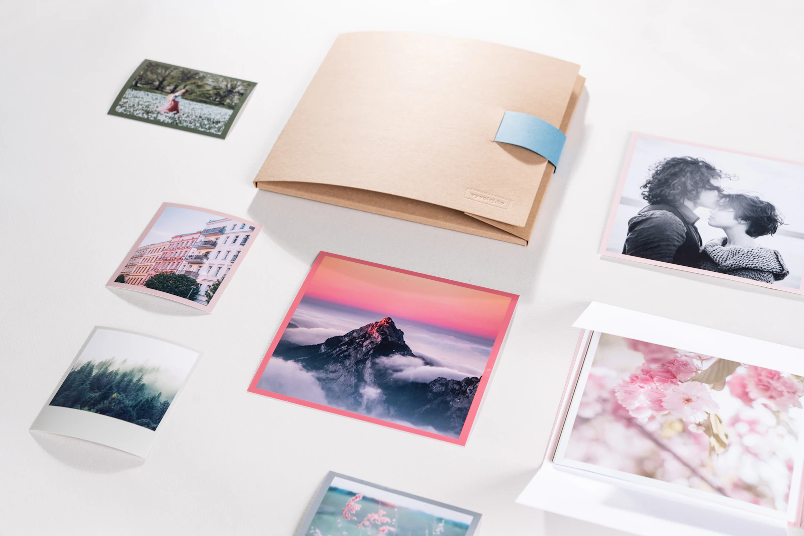 A collection of printed photographs arranged on a white table
