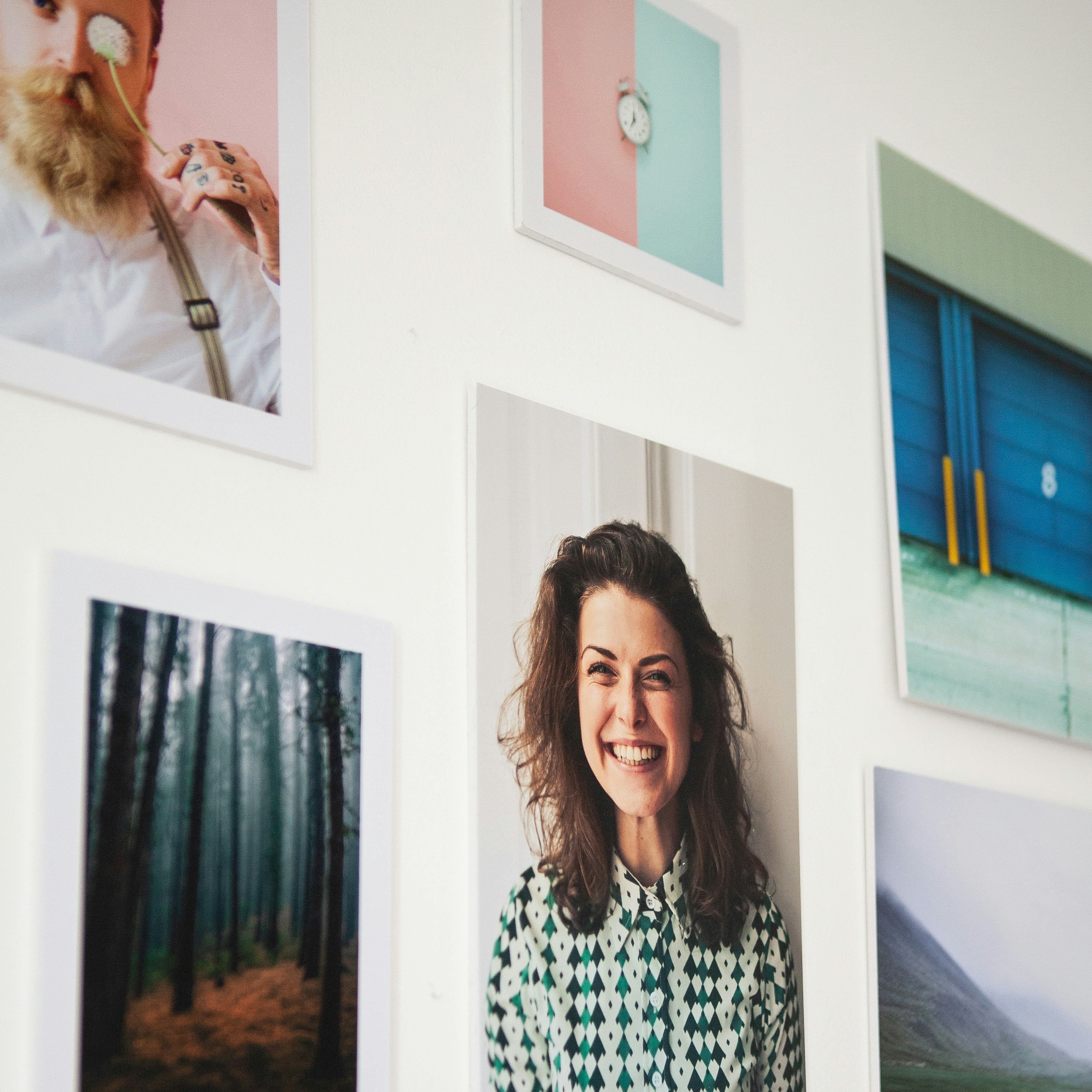 a woman standing in front of a wall with pictures on it