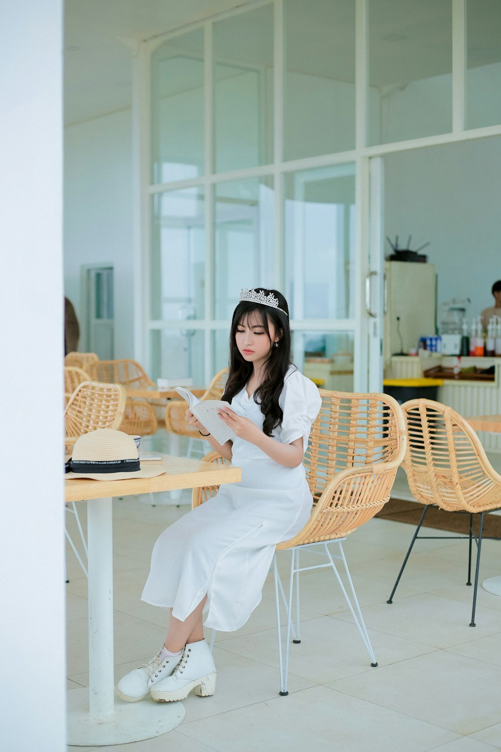 a woman in a white dress sitting at a table