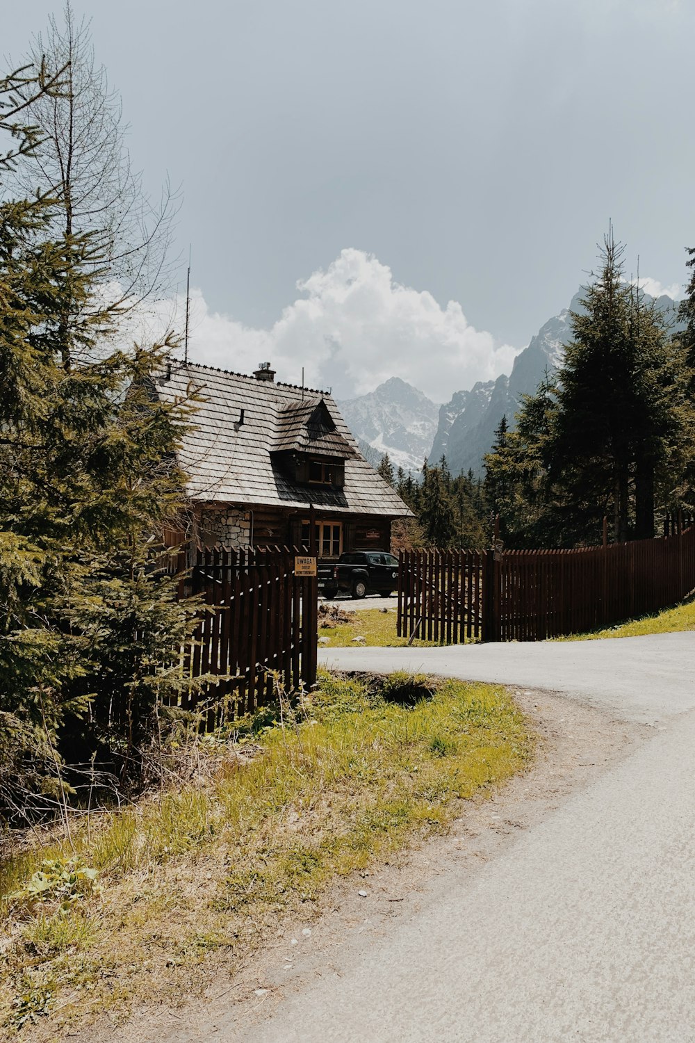 a house in the middle of a forest with mountains in the background