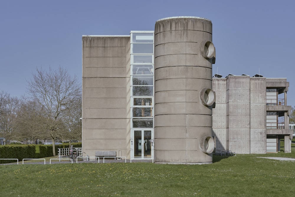 a large concrete building sitting on top of a lush green field