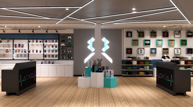 A modern retail store interior featuring shelves stocked with various merchandise including toys, figurines, and colorful boxes. The design includes sleek black counters with a gaming-themed logo, illuminated geometric light fixtures on the ceiling, and wooden flooring. Artwork and apparel are displayed on the walls, providing a vibrant and organized shopping environment.